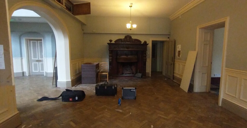 Interior of empty building with fireplace and acoustic measuring equipment on the floor